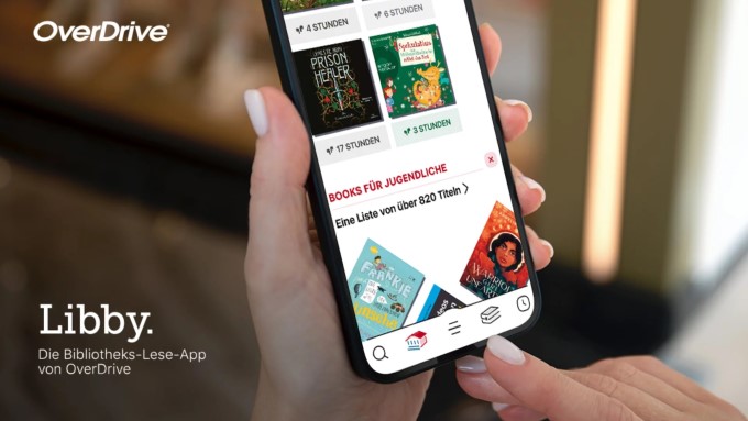 Symbolbild OverDrive. Eine Hand hält ein Smartphone auf dem die Libby-App geöffnet ist